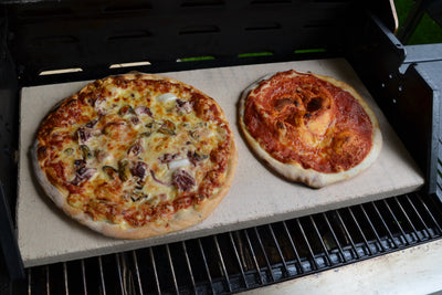 Pizzastein auf Gasgrill mit zwei Pizzas 